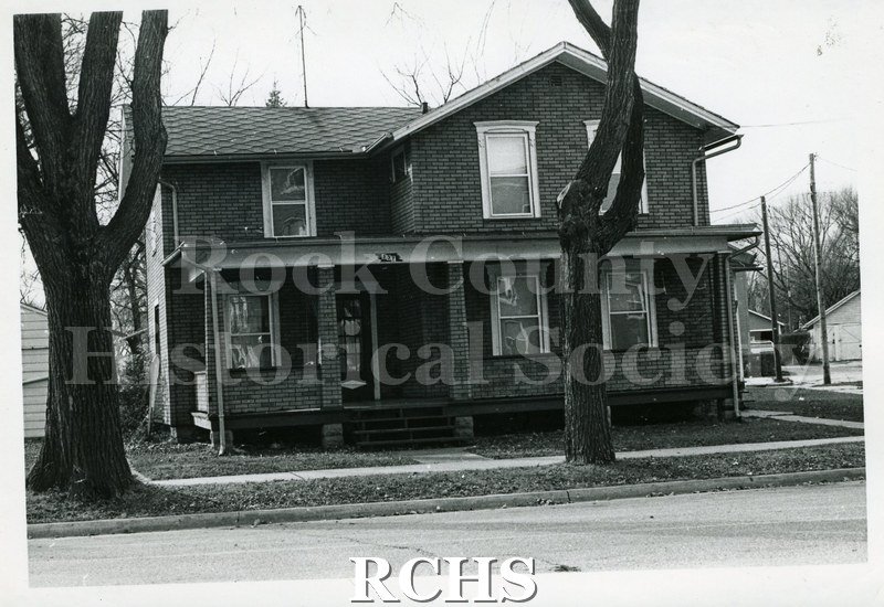 Black and white photograph of 537 Washington St., Janesville, WI (demolished c. July 1, 1971). Shows a two story house with a porch along the front of the house.