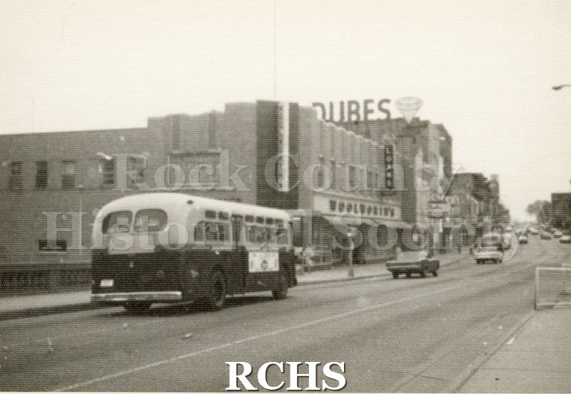 Black and white photograph of Woolworth's and Dubes Jewelry stores. The large sign on the roof of Dubes with a diamond is visible.