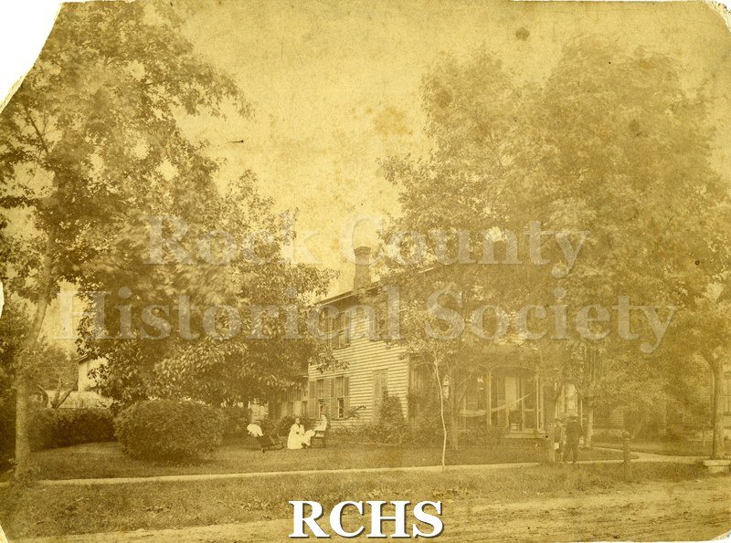 Historic image of Sepia phhotograph of 156 (now 162) Cherry St. Shows a house with two people sitting on lawn and two people standing in front.