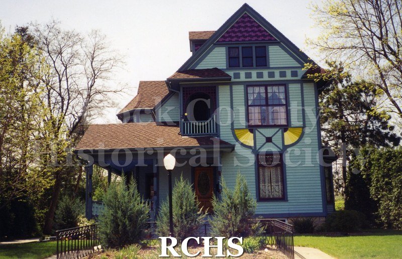 Color photo of the David Feingold home, 442 S. Garfield, Janesville, WI. Shows three story greenish colored sided house with landscaping in front.