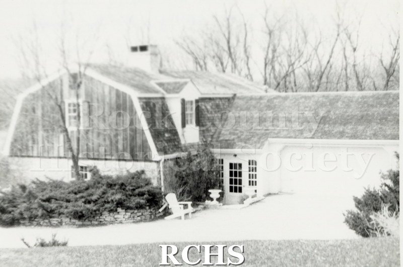 Black and white photograph of 2317 N. Parker Dr, a barn-like house with a double garage.