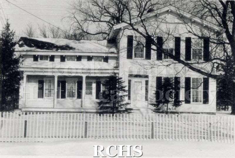 Black and white photograph of Green-Roberts House, a two story house with a one story addition on the left and a fence in front.