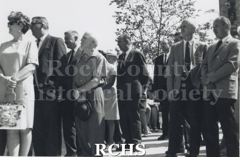 Black and white photograph of several men and women standing at attention, probably listening to a speaker. Duplicate of LD25.2000.40.