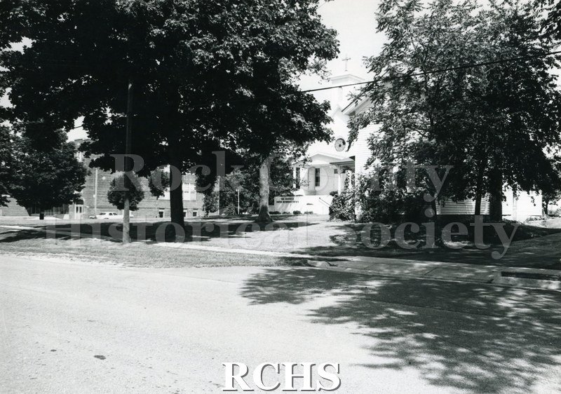 Historic image of Black and white copy print of Footville Methodist Churcha church. There is a school on the left.