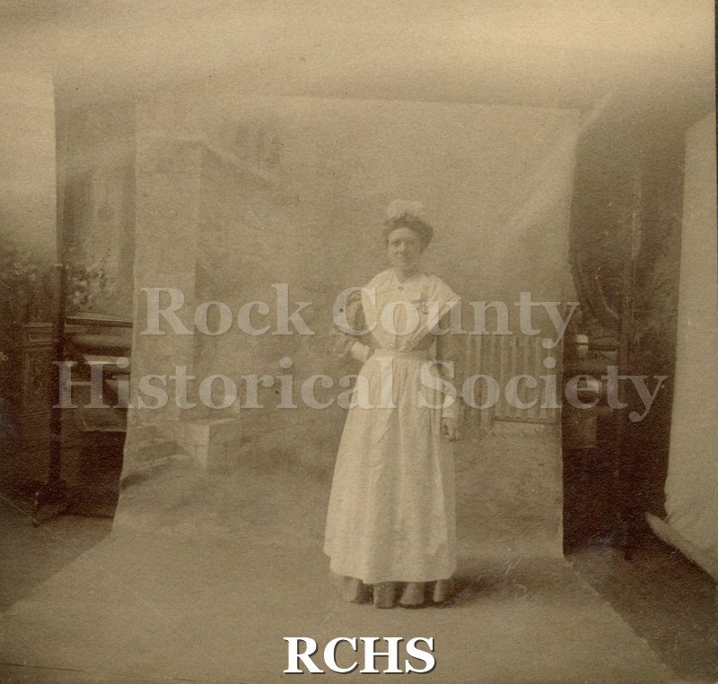 Black and white photograph of Minnie Tews and baby standing in a room.