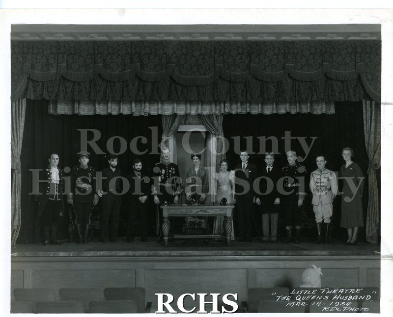 Black and white photograph of the cast of Janesville Little Theatre's 1934 production of "The Queen's Husband." Notation on lower right corner of photo: "LITTLE.