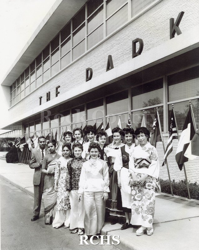 Black and white photograph of Parker Pennettes in foreign costume with flags. Shows 11 women and one man in different costumes of countries.