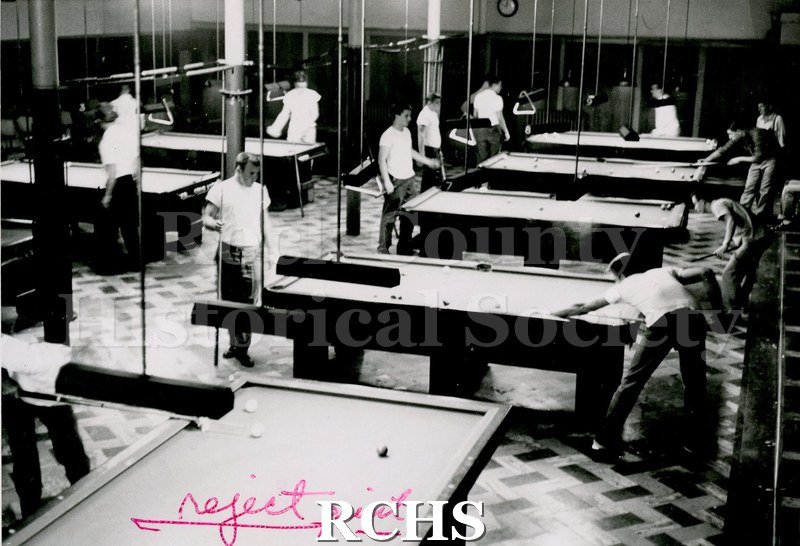 Black and white photograph of Kressin's Pool Hall. Shows several men playing pool in a pool hall.