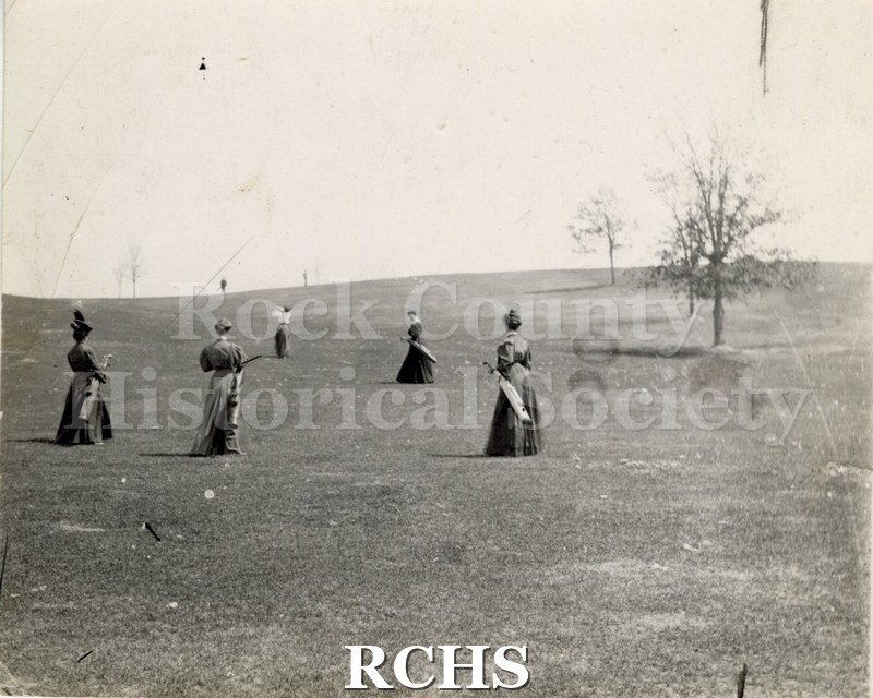 Black and white photograph of the Janesville Country Club. Five women are playing golf.