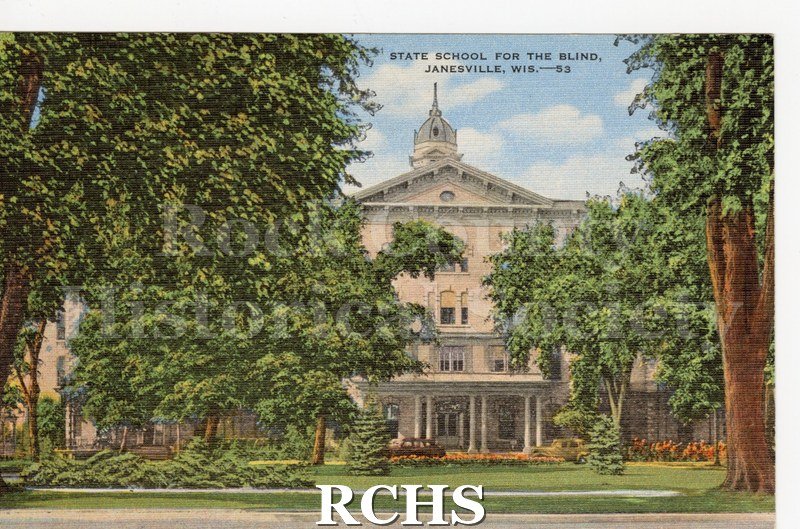 Postcard of State School for the Blind. Trees, flowers and 2 cars in foreground. No writing on reverse.