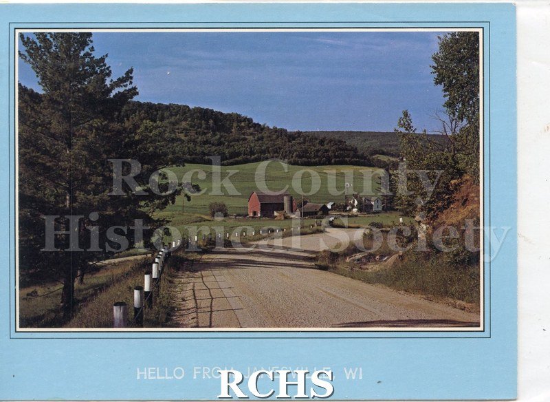 4 1/8 x 5 1/2". Front has picture of farmland. Gravel road extends out from view. In the middle and in the distance is a red barn with silo and farm house.