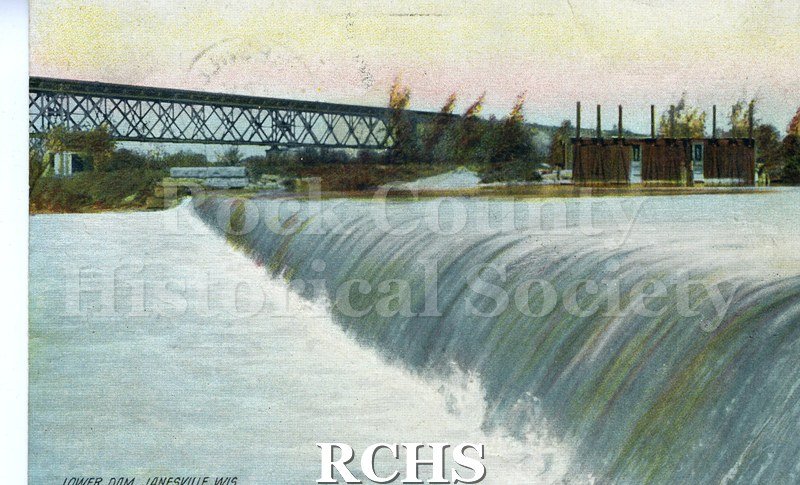 Postcard. Tinted image of the Chicago and North-Western Railroad bridge over the dam. Postmarked 10 September 1908 and addressed to Martha Lovelace.