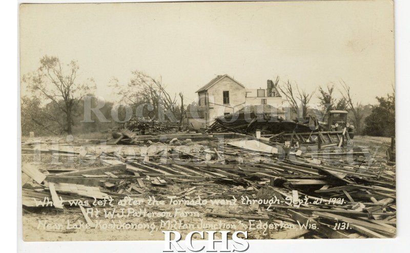 3-1/2" x 5-1/2" glossy picture postcard showing farm after tornado. Farmhouse seems to be intact. On bottom: "What was left after the Tornado went through Sept.