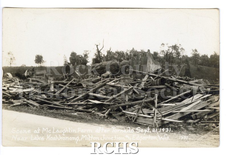 3-1/2" x 5-1/2" glossy picture postcard showing farm after tornado. Much debris is in the foreground.