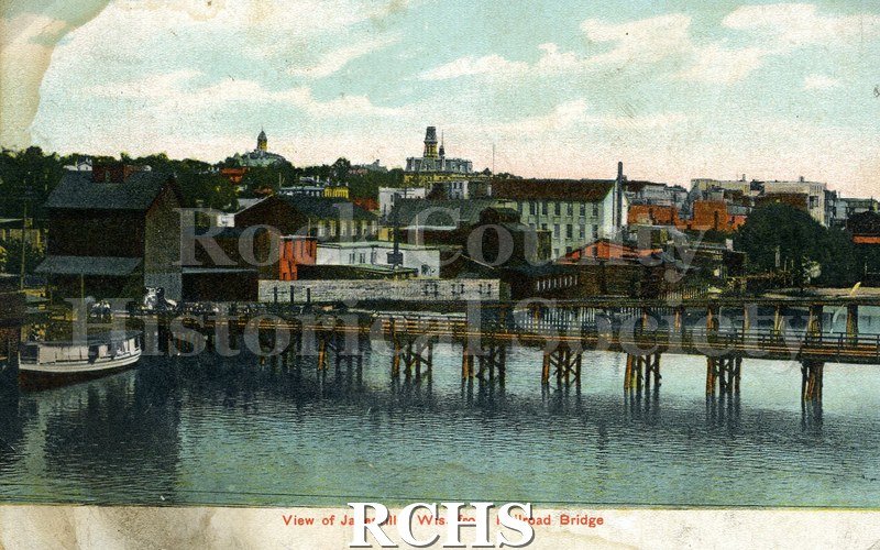 Postcard. Tinted image of Janesville from a downtown railroad bridge. Addressed to Maude Daniels of Mayville. Postmarked 21 June 1908.