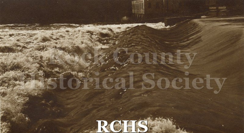 Historic image of Centerway Dam with water flowing over it.