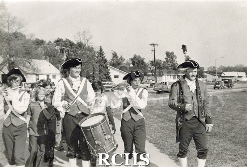 Historic image of Janesville Fife and Drum Corps marching along a street.