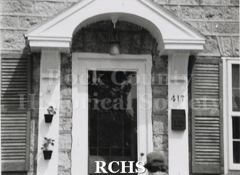 Historic image of Doorway of 417 Bluff St. Shows flower pots on the left and a mailbox on the right below the number 417.