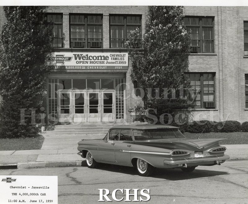 Black and white aerial photograph of the 4 millionth car parked in front of the Chevrolet plant office, June 17, 1959.