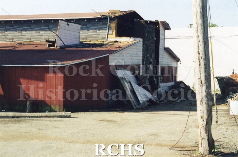 Color photo of demolition of Slick's Bar, Milton Avenue. Bar owned by Dean Richards and Jim Comstock. Leased from Joe Adamany. Shows building from side.