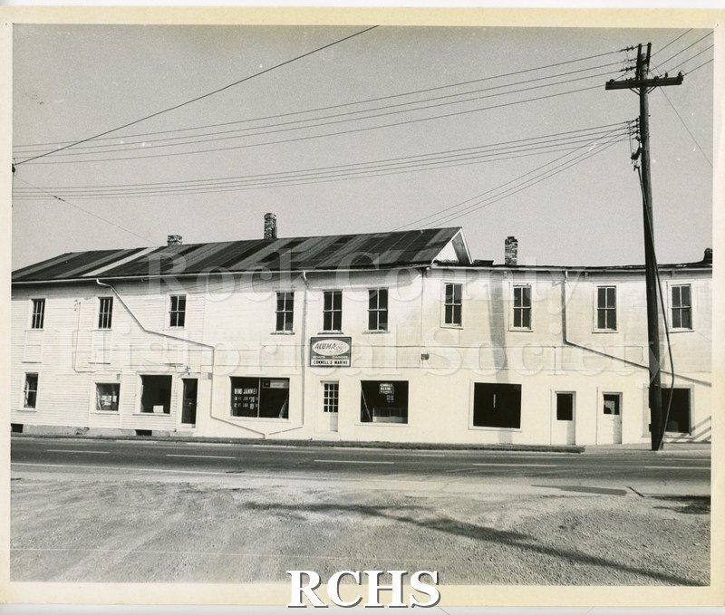 Black and white photograph of Connell's Marine, 16 W. Court. Shows a two story building with sign: "Aluma Craft Boats Canoes Connell's Marine".