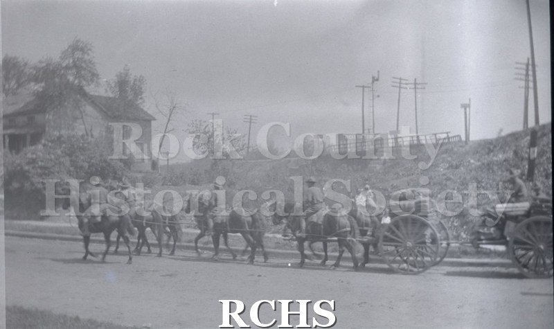 Black and white photograph of horses pulling a caisson along a street. Armistice Day Parade 11/11/1917, Janesville Wi Scanned from negative.