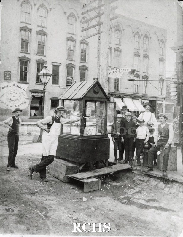 Black and white photograph of a popcorn stand at corner of Main and Milwaukee Street, Janesville, WI, 1885.