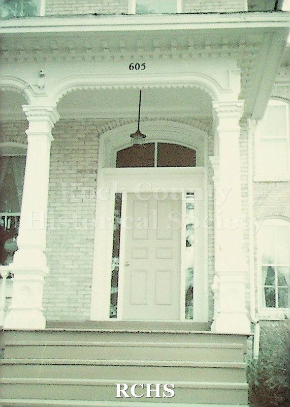 Colored photograph, dated 1976 of Milton College Picture of front enterance of building with address number 605.