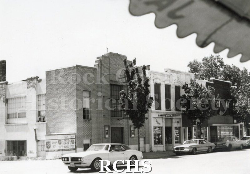 Historic image of North Main Street with Larry's Fast Service on the ground floor of one of the buildings.